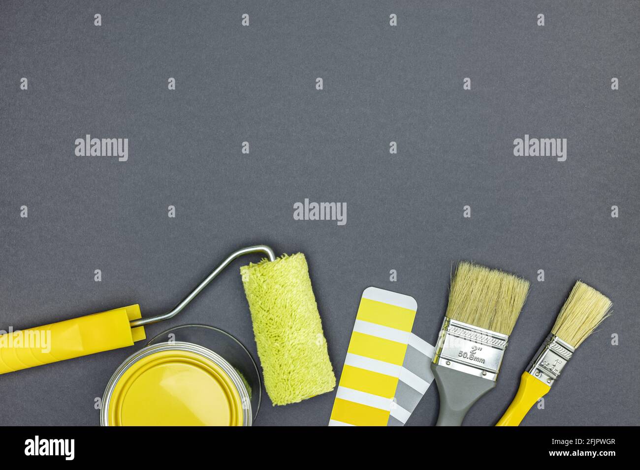 Werkzeuge für Hausverbesserungsarbeiten. Pinsel, Farbrolle, Farbtonnen und Farbfelder auf grauem Hintergrund. Draufsicht Stockfoto
