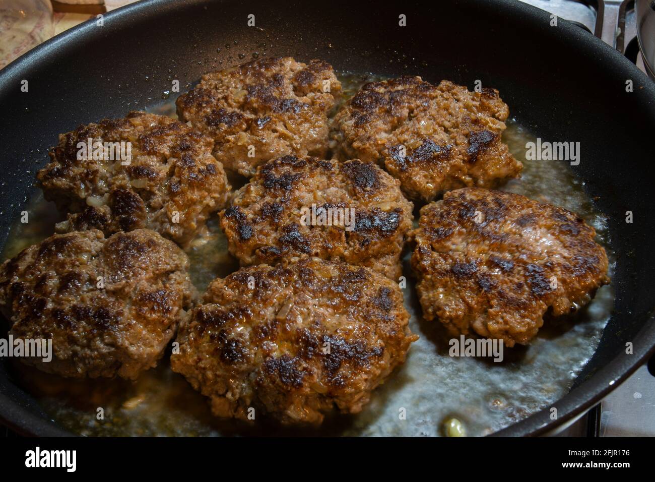 Fertig zum Essen. Hausgemachte Burger-Fleischbällchen werden in einer gusseisernen Pfanne gekocht. Selective Focus Burger Frikadellen. Stockfoto