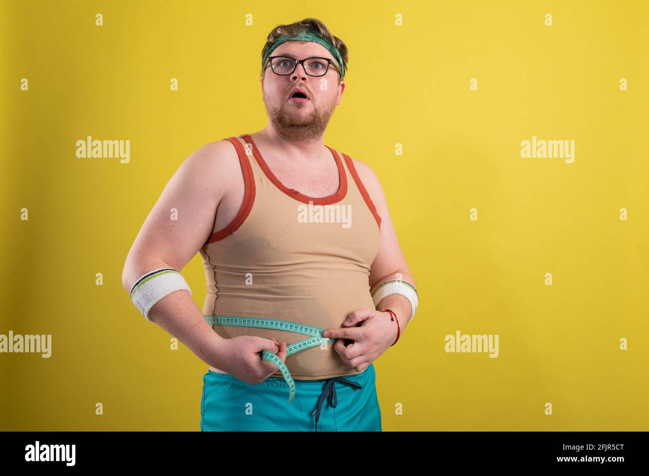 Ein Mann in Sportbekleidung misst sein Körpervolumen. Gesundes Lifestyle-Konzept, gesunde Ernährung Stockfoto