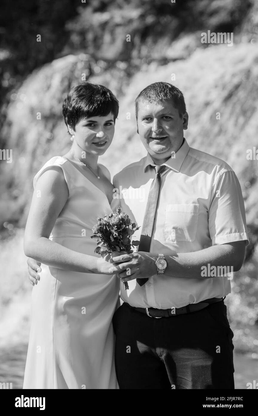 Brautpaar auf dem Hintergrund eines Wasserfalls Stockfoto