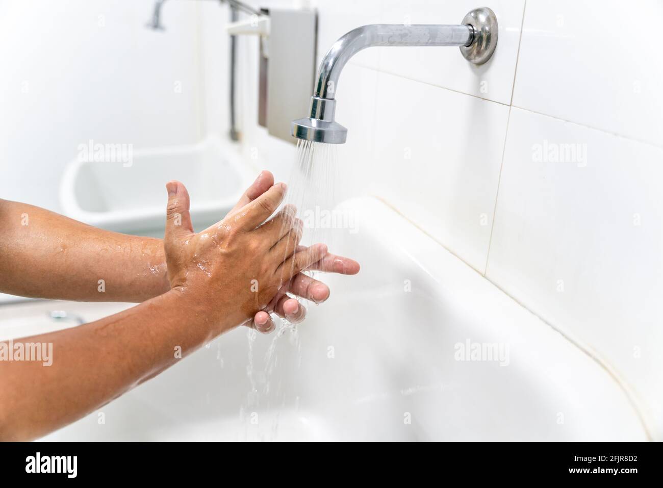 Hand of man wasche deine Hände am Waschtisch mit Schaum, reinige die Haut und fließ Wasser durch die Hände. Gesundheit für COVID-19 Prävention con Stockfoto