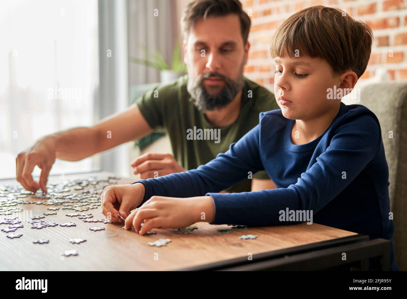 Nahaufnahme von Vater und Sohn lösen Puzzle Stockfoto