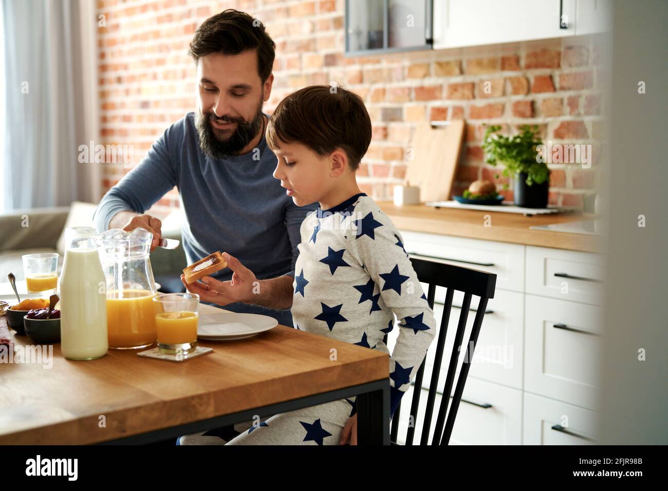 Glücklicher Vater und Sohn beim gemeinsamen Frühstück am Morgen Stockfoto