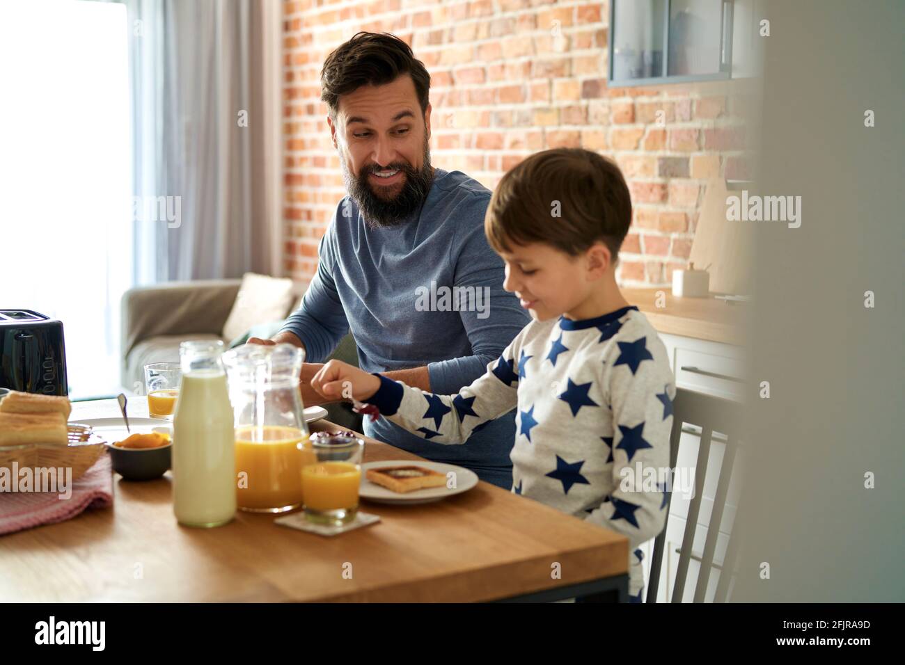 Glücklicher Vater und Sohn beim Frühstück am Morgen Stockfoto