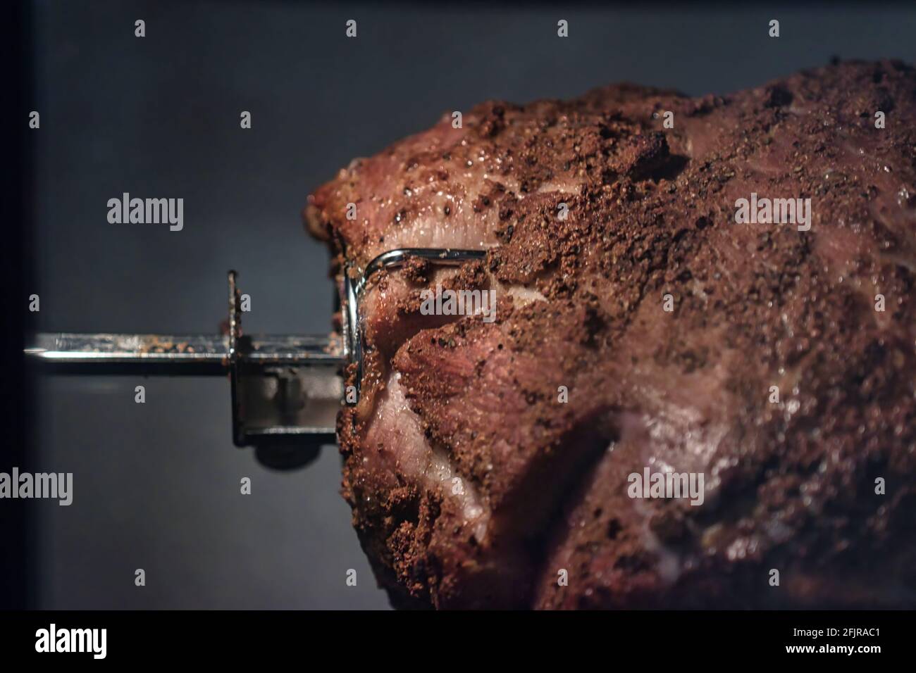 Schweinebraten spinnen und tropfendes Fett auf einer Rotisserie Stockfoto