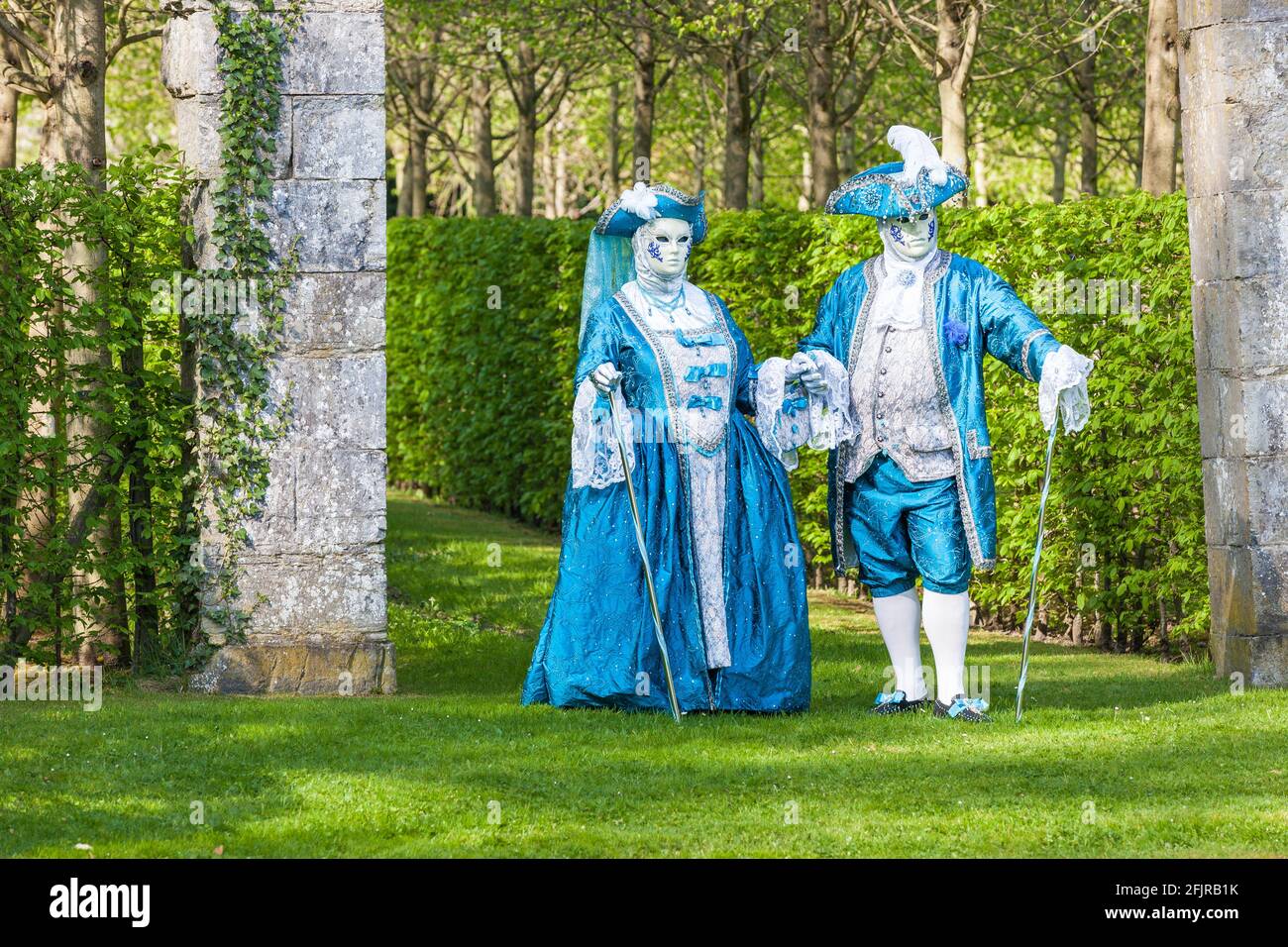 Ein Paar in venezianischem Kostüm, das in einem Park posiert Stockfoto