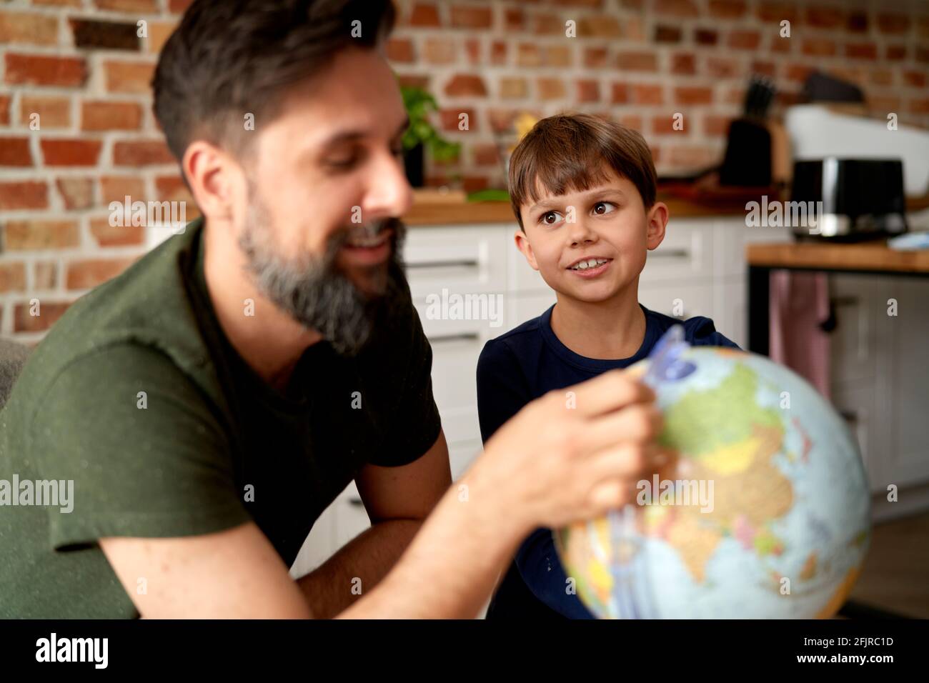 Vater und Sohn sitzen mit Globus und planen Reisen Stockfoto