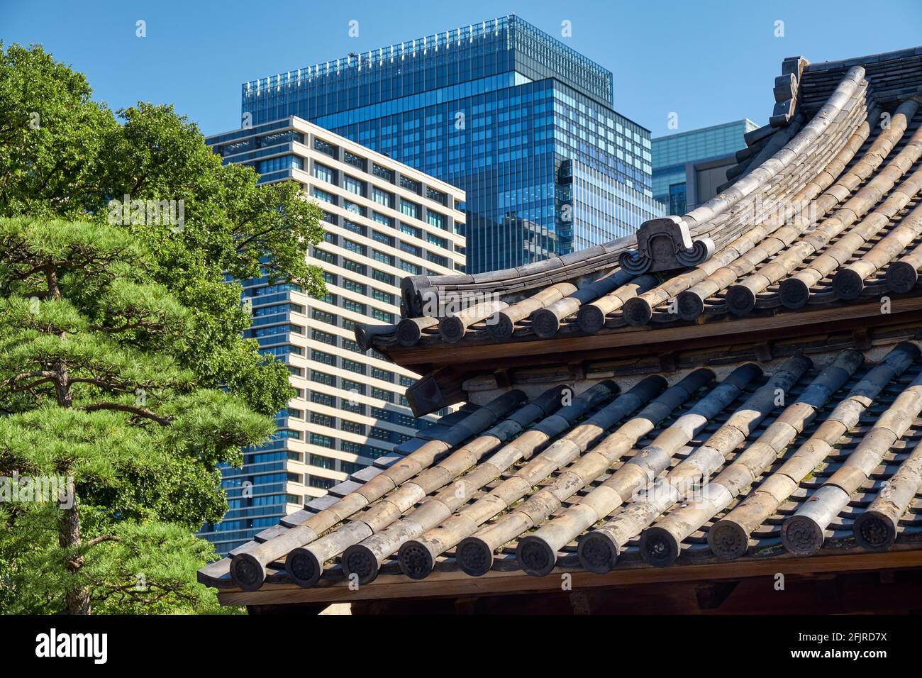 Der Blick auf das alte traditionelle geschwungene Dach des Kaiserpalastgebäudes und die modernen Wolkenkratzer des Handelszentrums im Chiyoda-Bezirk von Tokio. Japa Stockfoto