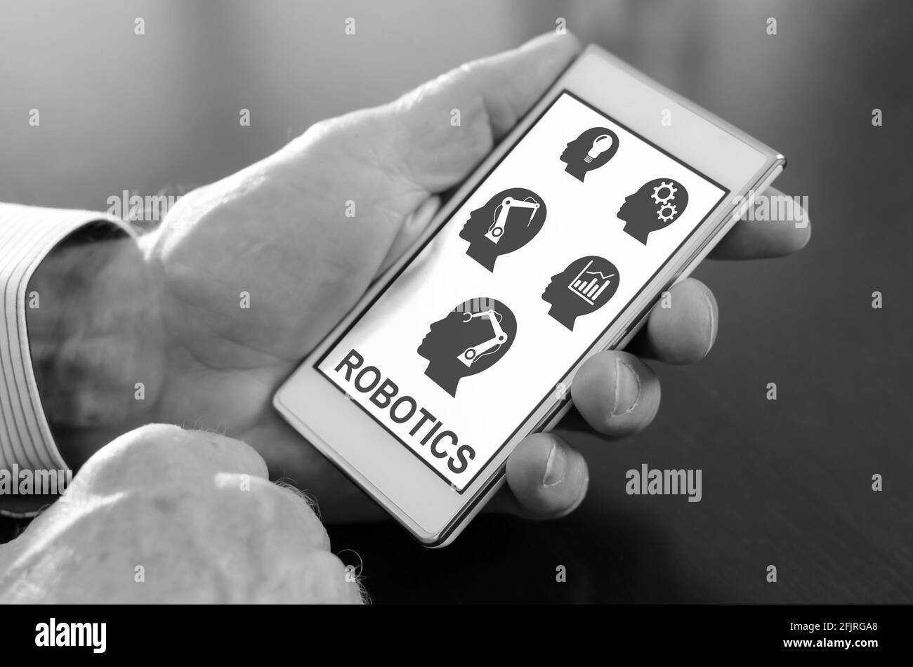 Hand hält ein Smartphone mit Robotik-Konzept Stockfoto