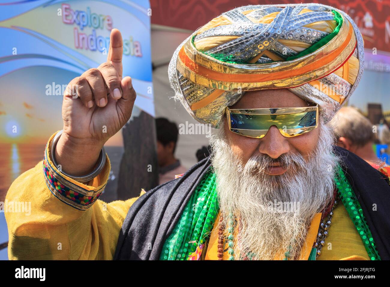 Der punjabische Sikh-Mann Kala Kala in farbenfrohem Dastar-Turban und lebendiger traditioneller Kleidung posiert lächelnd auf einem asiatischen Festival auf dem Trafalgar Square in London Stockfoto