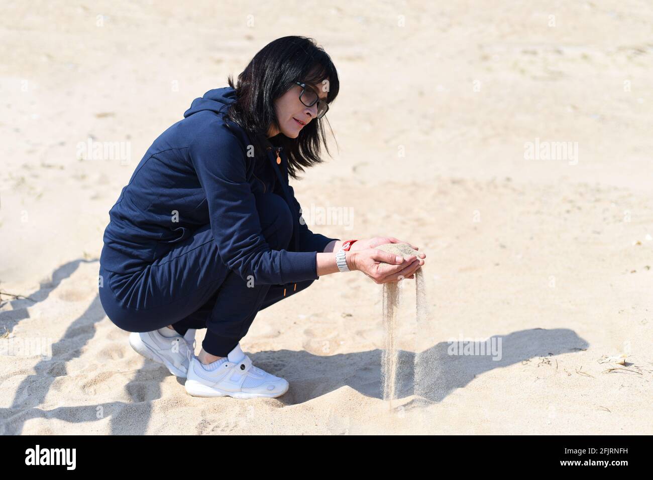 Sand fällt durch deine Finger Stockfoto