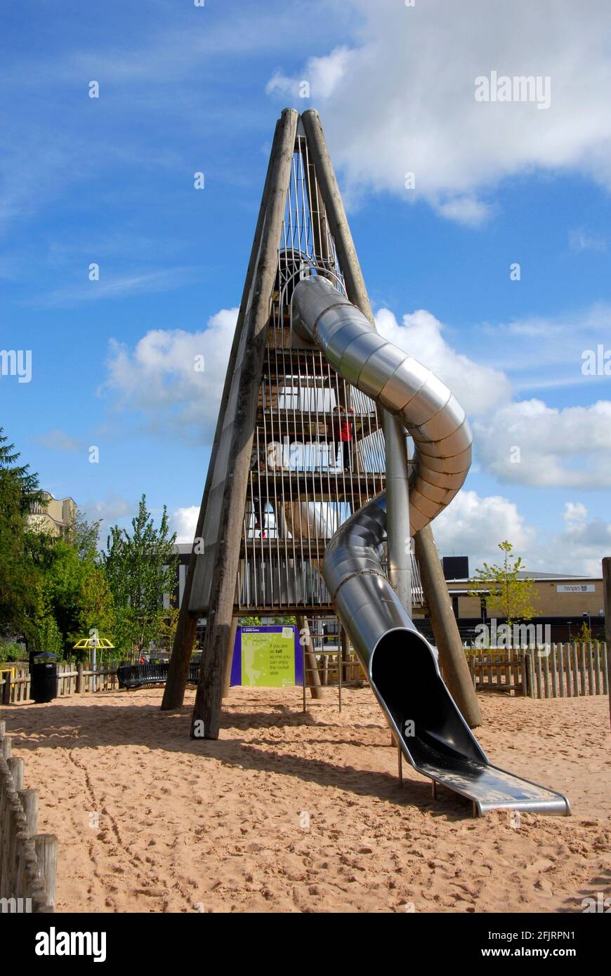 Hohe vierseitige Struktur mit gebogenem, geschlossenen Rohr, das als Kinderrutsche fungiert, Telford Town Park, Shropshire, England Stockfoto