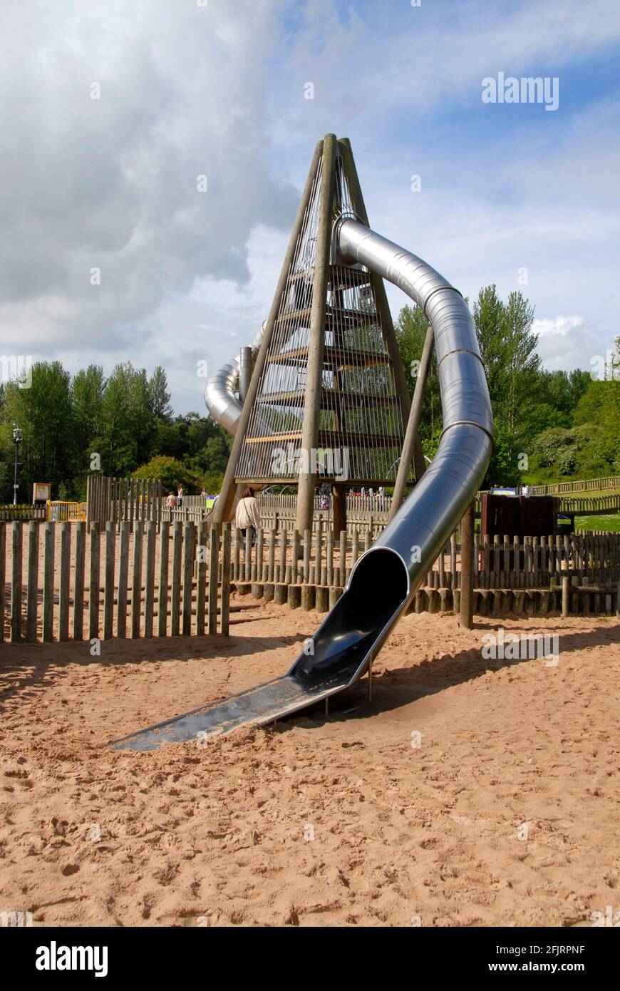 Hohe vierseitige Struktur mit gebogenem, geschlossenen Rohr, das als Kinderrutsche fungiert, Telford Town Park, Shropshire, England Stockfoto