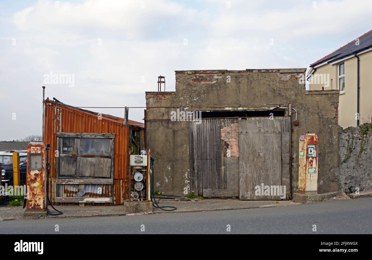 Alte Garage mit rostigen Pumpen und Schildern, in Wales. Stockfoto