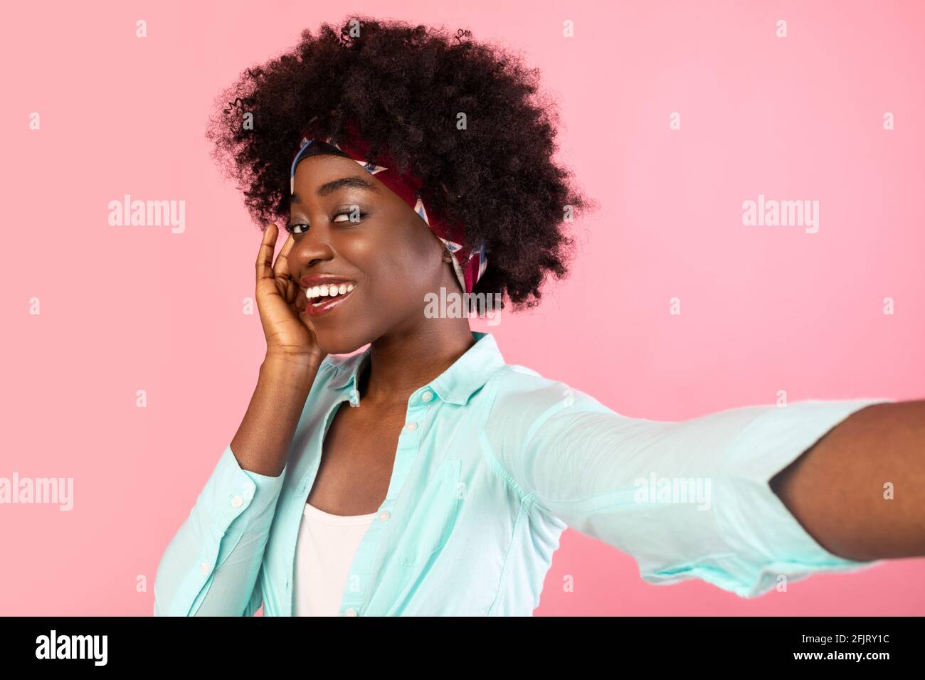 Buschige Afroamerikanische Lady Macht Selfie Posiert Berührendes Gesicht, Rosa Hintergrund Stockfoto