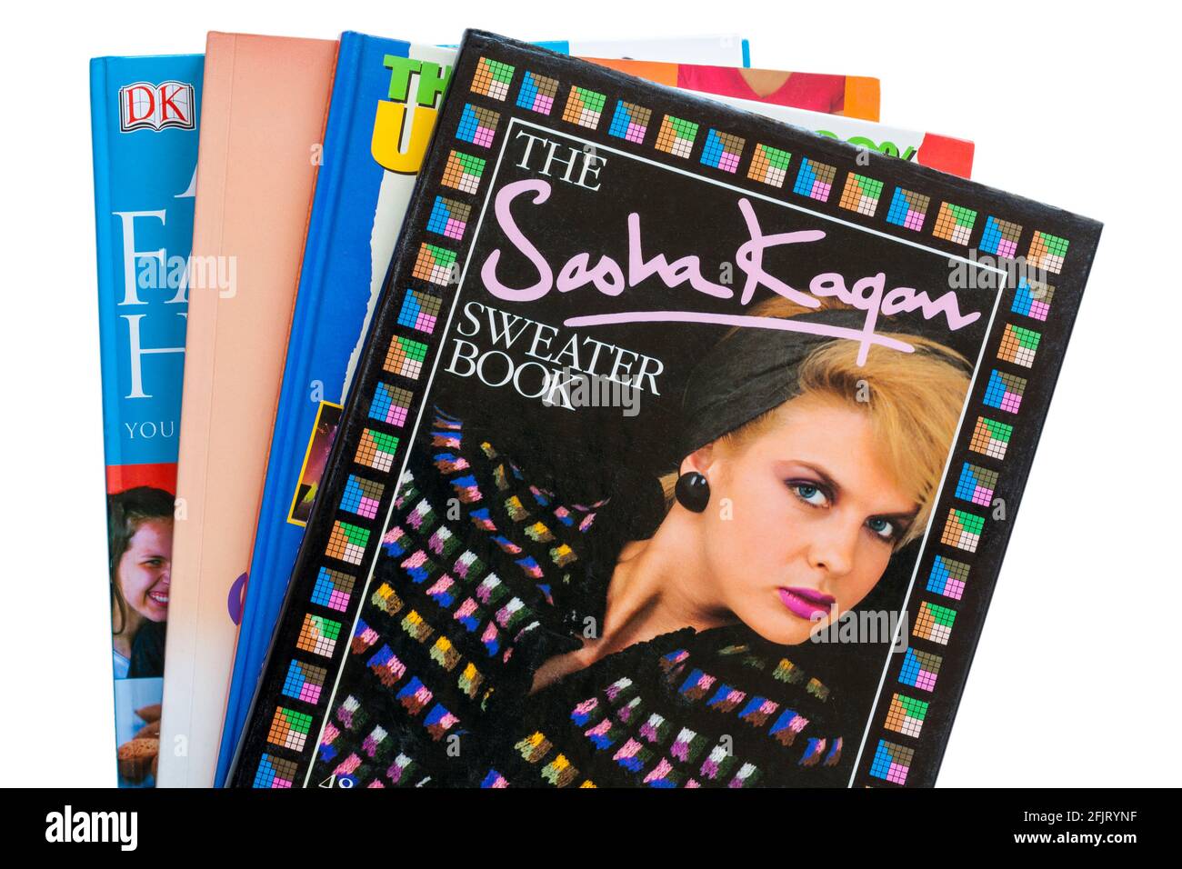 Bücherstapel mit dem Sasha Kagan Sweater Book on Top auf weißem Hintergrund gesetzt Stockfoto