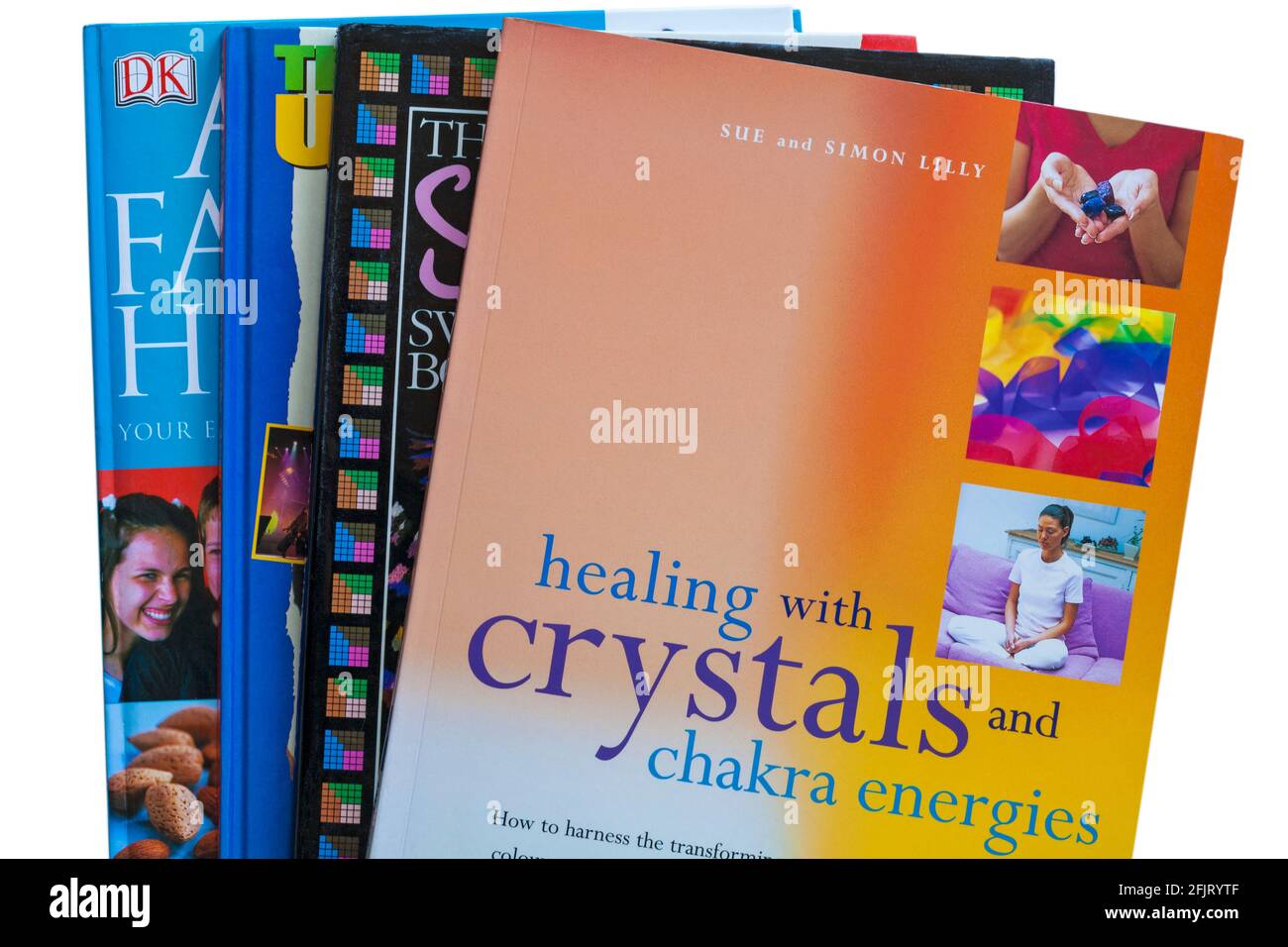 Stapel von Büchern mit Heilen mit Kristallen und Chakra-Energien Buch oben auf weißem Hintergrund Stockfoto