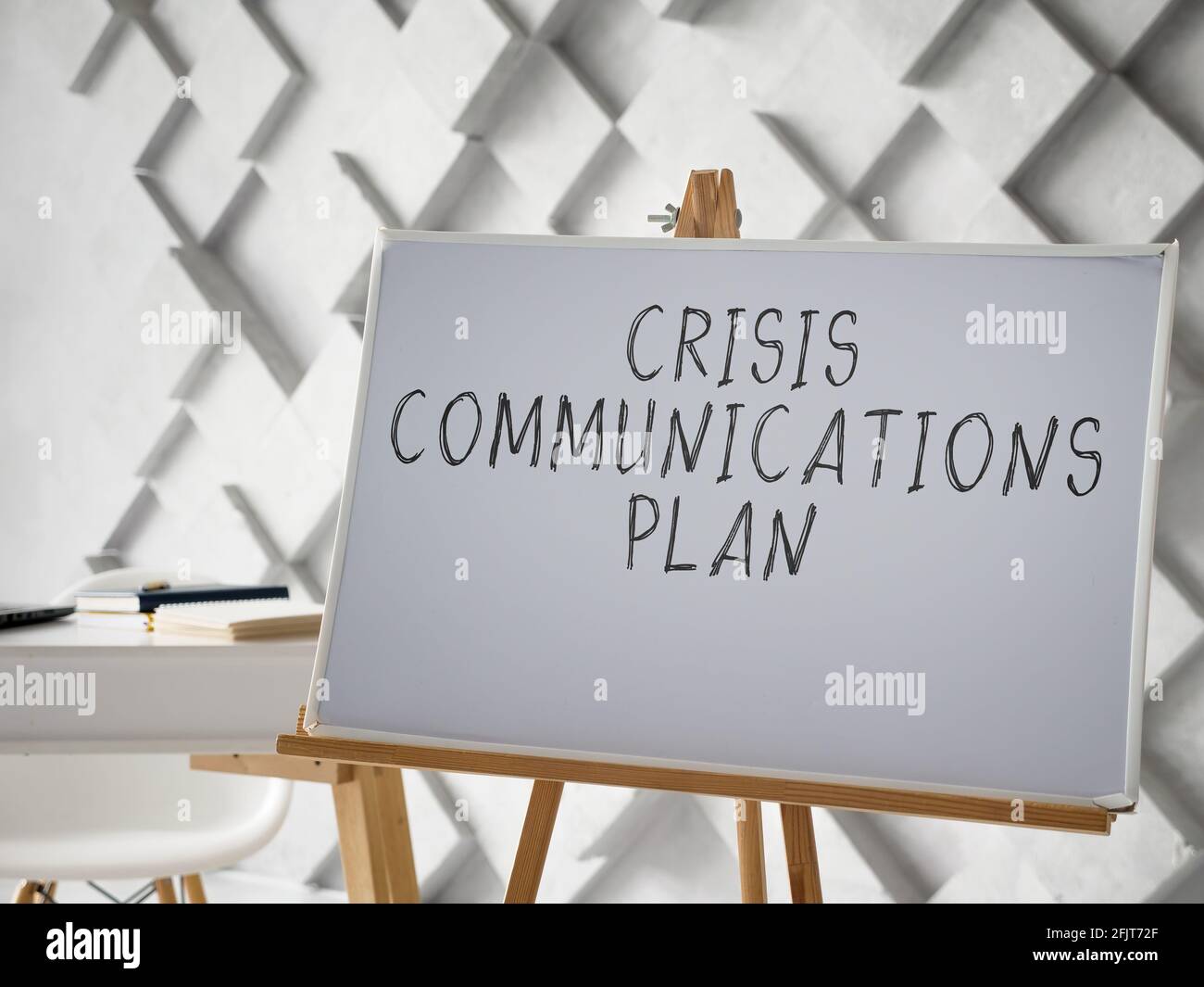 Krisenkommunikationsplan auf weißem Schreibtisch geschrieben. Stockfoto