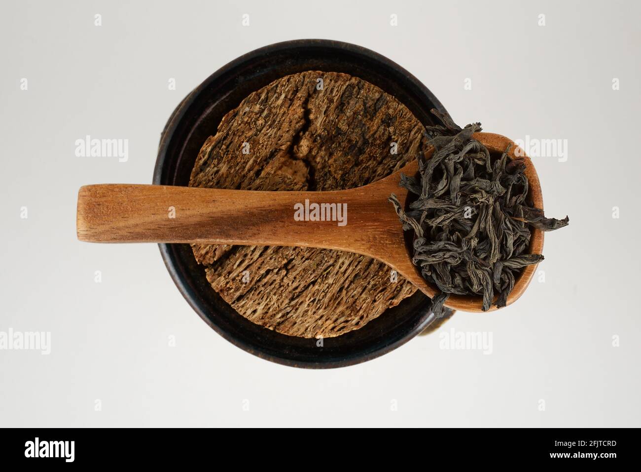 Schwarze Teeblätter in einem Holzlöffel Stockfoto