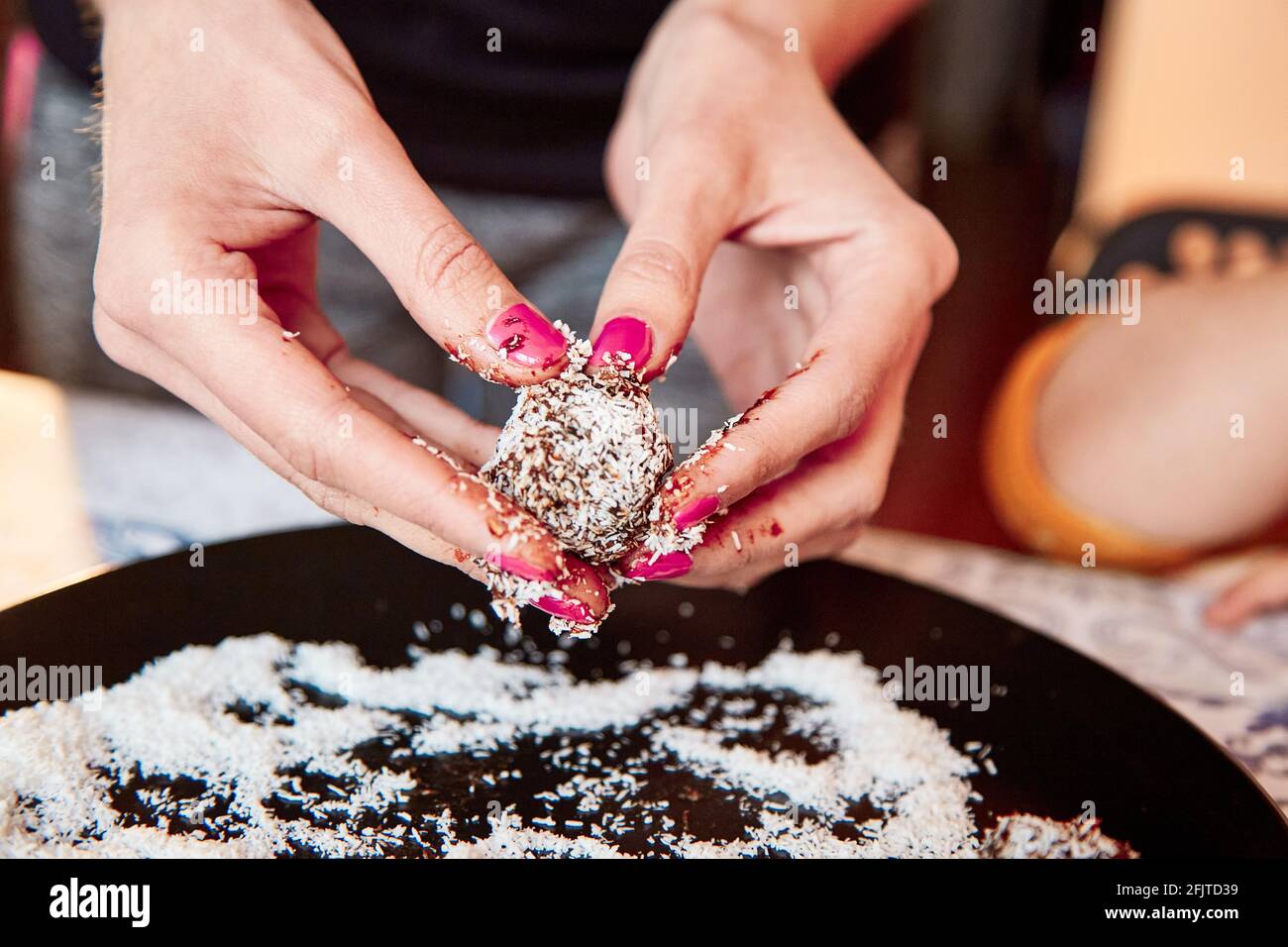 Gesunde Süßigkeiten ohne Zucker aus getrockneten Früchten und Kokosflocken zu Hause machen. Nahaufnahme. Selektiver Fokus Stockfoto