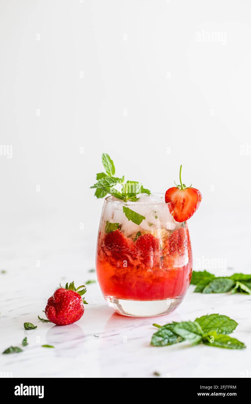 Frisches Erdbeergetränk. Erdbeer-Mojito. Auf einem weißen Marmortisch mit Erdbeeren und frischer Minze. Stockfoto
