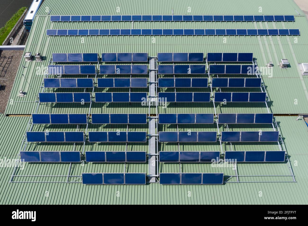 Warmwasserbereiter und Sonnenkollektoren auf dem Gebäude installiert Dach Stockfoto
