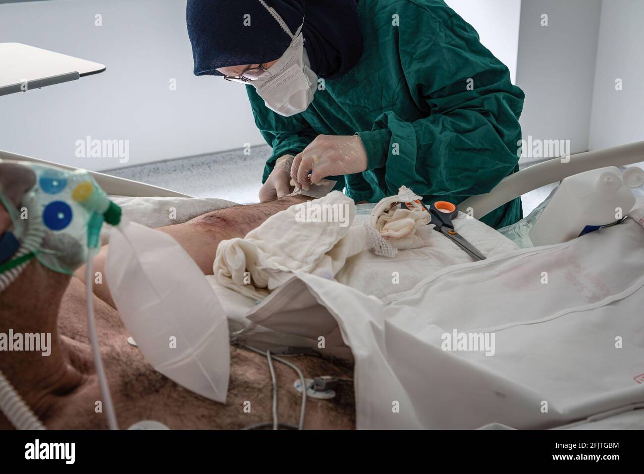 Ankara, Türkei. April 2021. (ANMERKUNG DER REDAKTION: Die Abbildung enthält grafische Inhalte) EINE Krankenschwester, die persönliche Schutzausrüstung (PSA) trägt, öffnet einen vaskulären Zugang, um einem COVID-19-Patienten Medikamente zu verabreichen. Medizinische Fachkräfte, die im Stadtkrankenhaus Ankara arbeiten, kämpfen mit der Krankheit auf der Intensivstation, die COVID-19 vorbehalten ist. Die Türkei hat bisher 4,629,969 Coronavirus-Fälle bestätigt, 4,073,644 davon wurden geborgen. (Foto von Tunahan Turhan/SOPA Images/Sipa USA) Quelle: SIPA USA/Alamy Live News Stockfoto