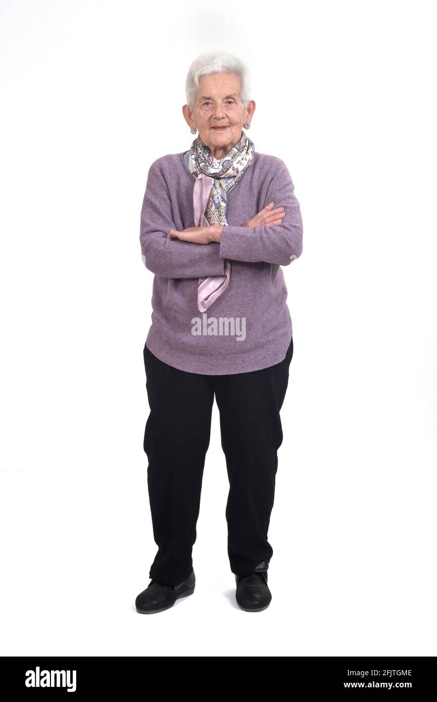 Vollportrait einer älteren Frau, gekreuzte Arme, auf weißem Hintergrund Stockfoto