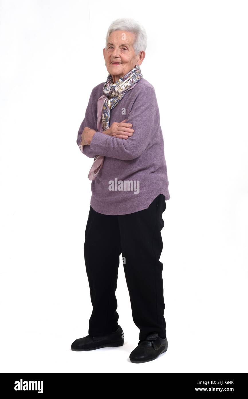 Vollständiges Porträt einer älteren Frau Arme gekreuzt und lächelnd Auf weißem Hintergrund Stockfoto