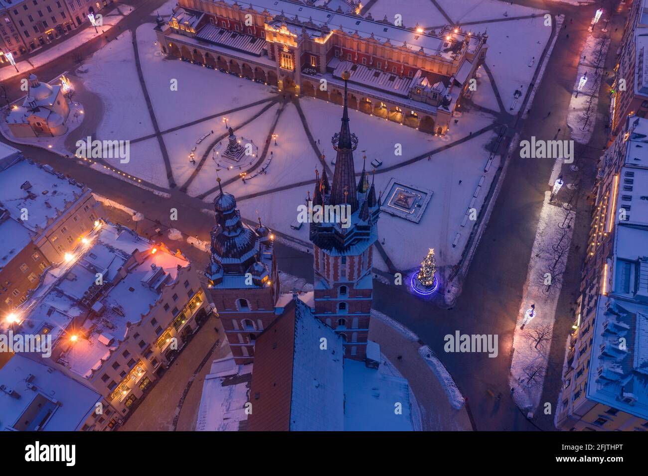 Krakau Polen Hauptplatz Rynek der Altstadt im Winter Luftaufnahme. St. Mary's Basilica Gotische Kirche und Krakauer Tuchhalle, bedeckt mit Schnee am Vorabend Stockfoto