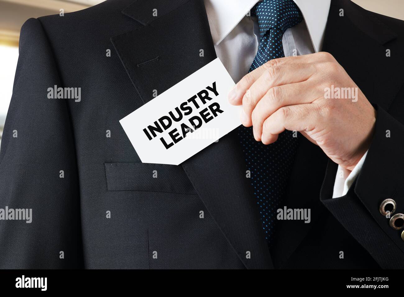 Geschäftsmann nimmt eine Visitenkarte aus seiner Tasche mit dem Nachrichtenindustrieführer. Führungskonzept der Industrie. Stockfoto