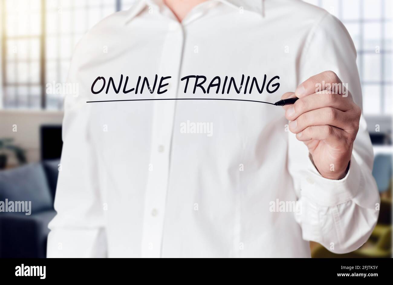 Businessman Hand hält einen Stift und unterstreicht die Worte Online-Training auf einem virtuellen Bildschirm. Online-Fernschulungskonzept. Stockfoto