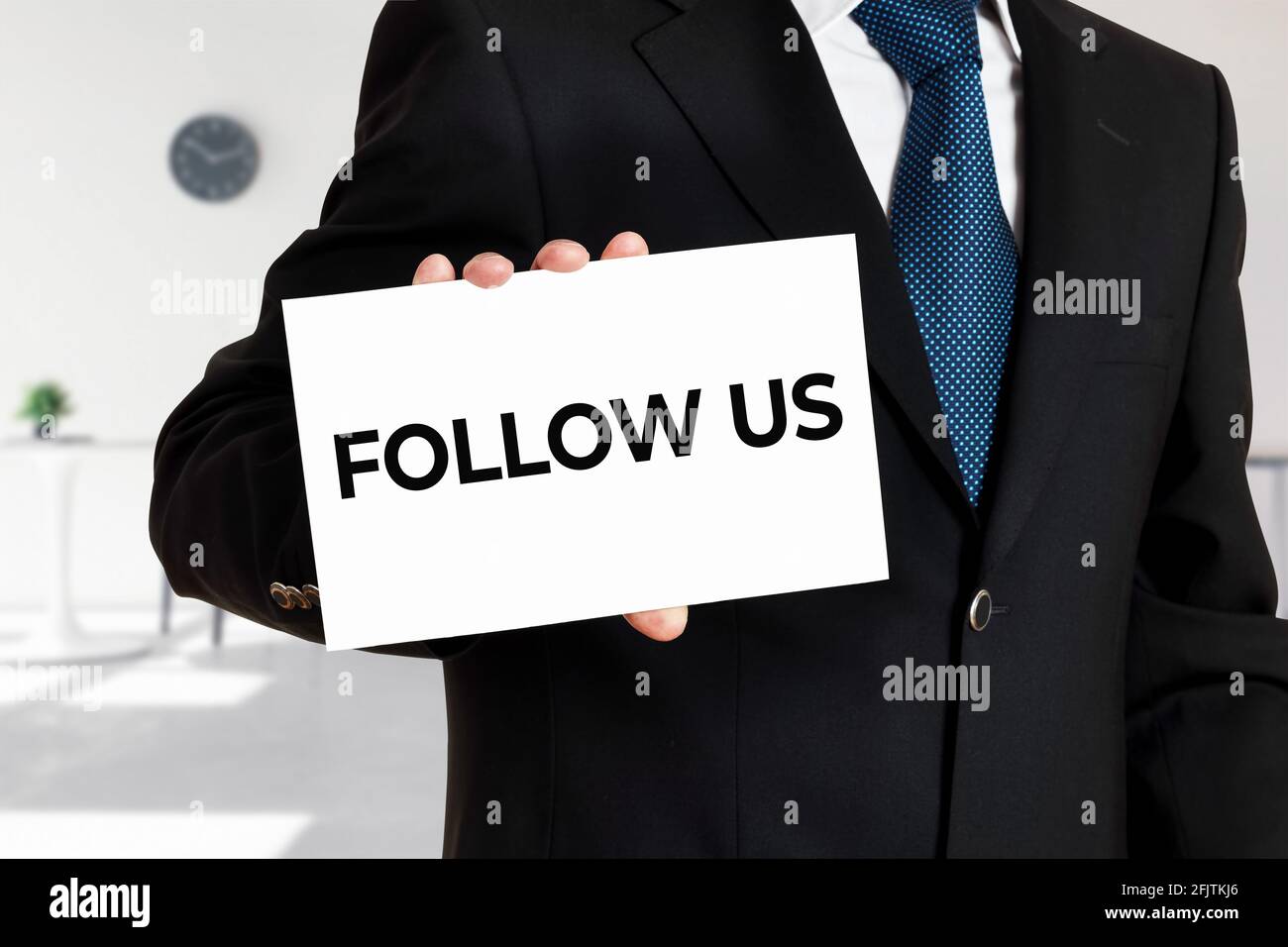 Geschäftsmann hält eine Karte mit dem Wort folgen Sie uns. Business- oder Social-Media-Konzept. Stockfoto