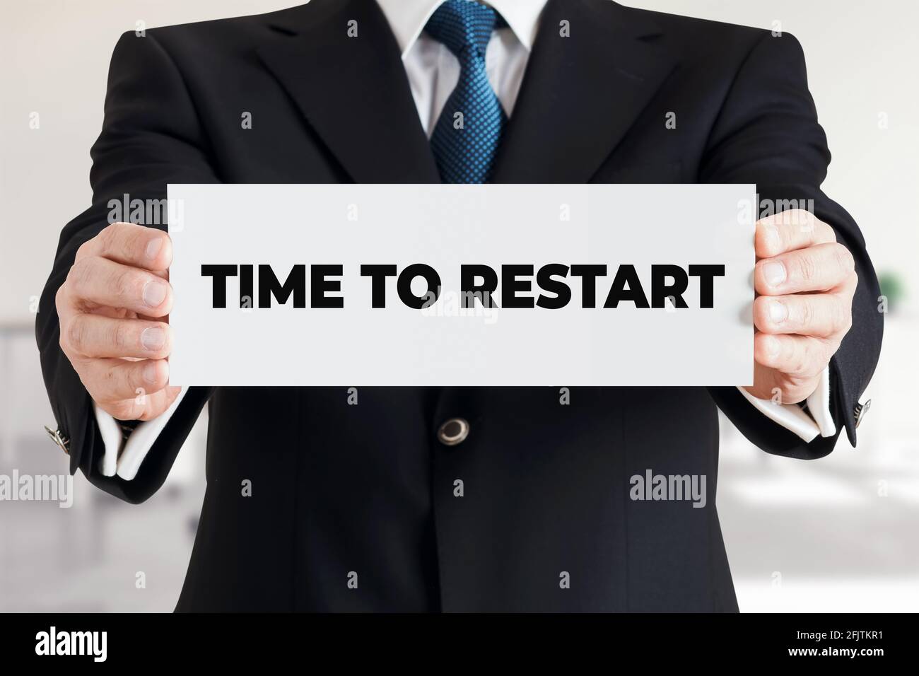 Geschäftsmann zeigt ein Banner mit der Nachricht Zeit zum Neustart. Neue Einstiegsmöglichkeiten im Business Career Concept. Stockfoto