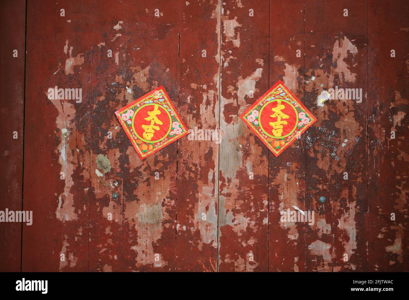 Geschlossene Tür mit rostiger roter Farbe, wie das chinesische Wort „großes Glück“ Stockfoto