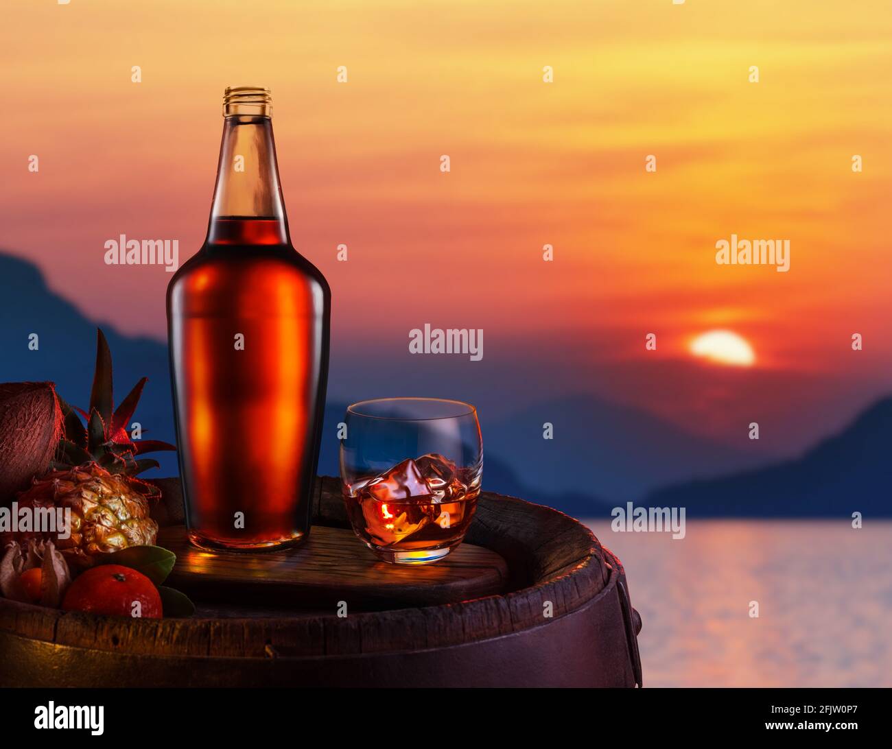 Glas vereisten dunklen Rums und tropische Früchte auf einem Eichenfass. Rot schöner Sonnenuntergang am Meer. Stockfoto
