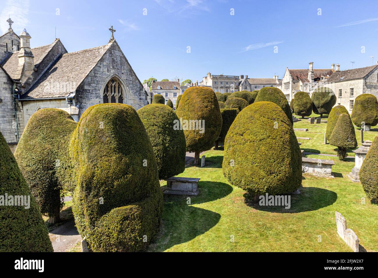 St Marys Kirche mit einigen seiner 99 Eibenbäume in der Cotswold Dorf Painswick, Gloucestershire UK Stockfoto