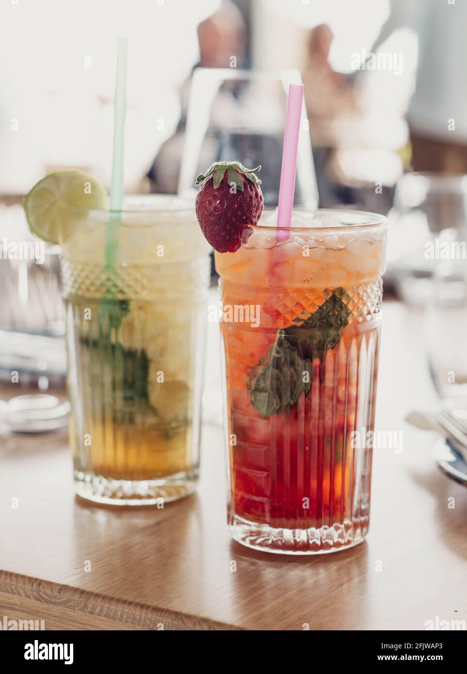 Zwei Mojito-Cocktails mit gereiftem Rum, Minze und verschiedenen Früchten. Eine Erdbeere und die andere Passionsfrucht Stockfoto