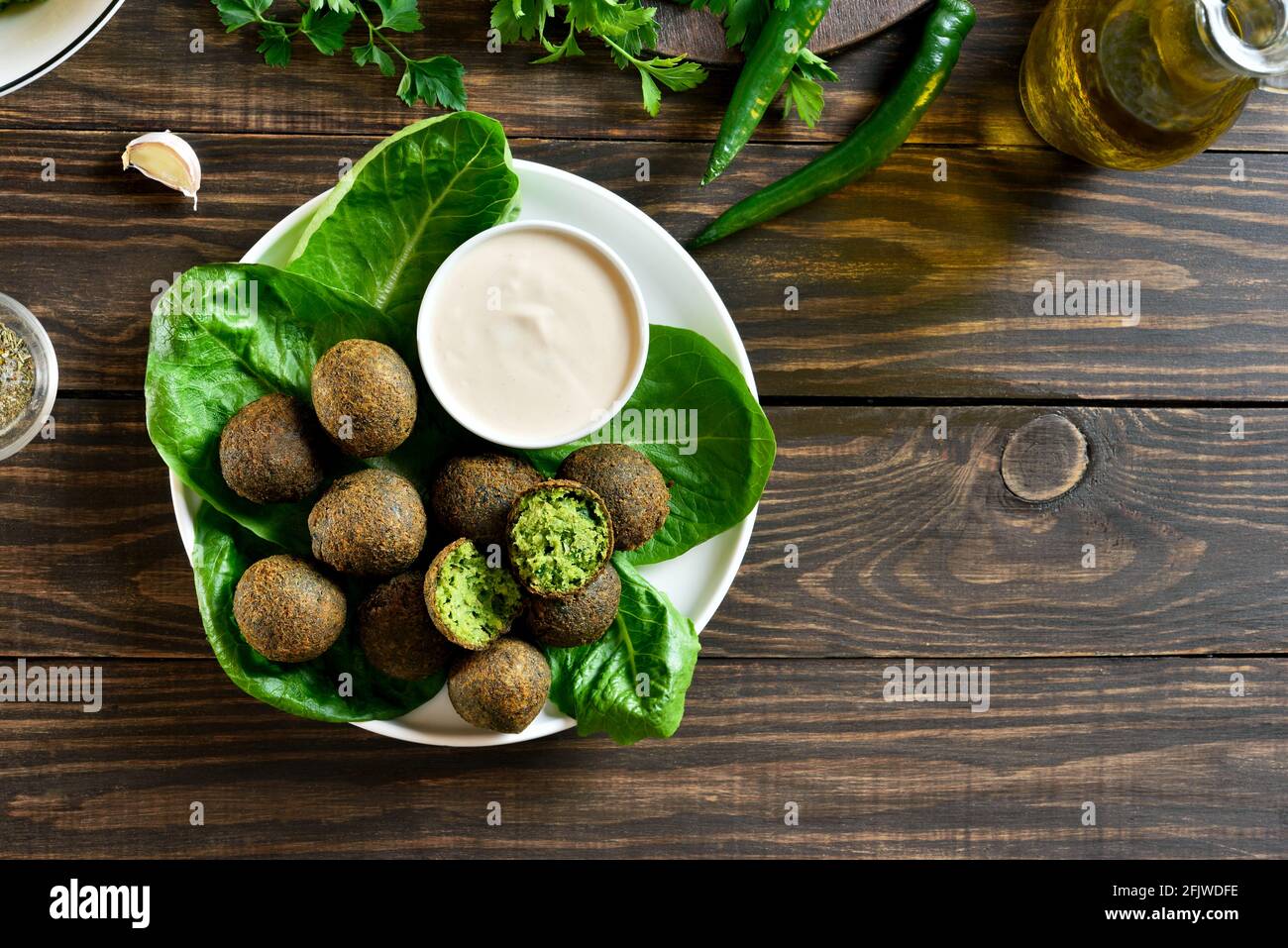 Falafel-Kugeln. Frittierte Kugeln aus gemahlenen Kichererbsen. Traditionelle Gerichte aus dem Nahen Osten. Holzhintergrund mit Freitextraum, Draufsicht, flaches Lay, Kl Stockfoto