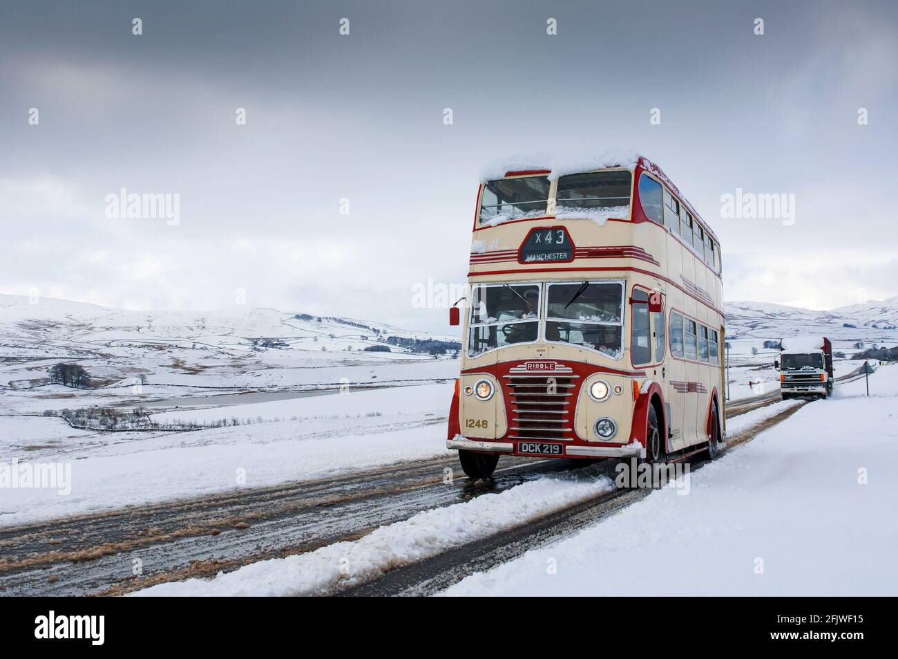 Klassischer Doppeldecker-Ribble-Bus auf einer verschneiten Straße in Cumbria bei Ravenstonedale auf der A684, Großbritannien. Stockfoto
