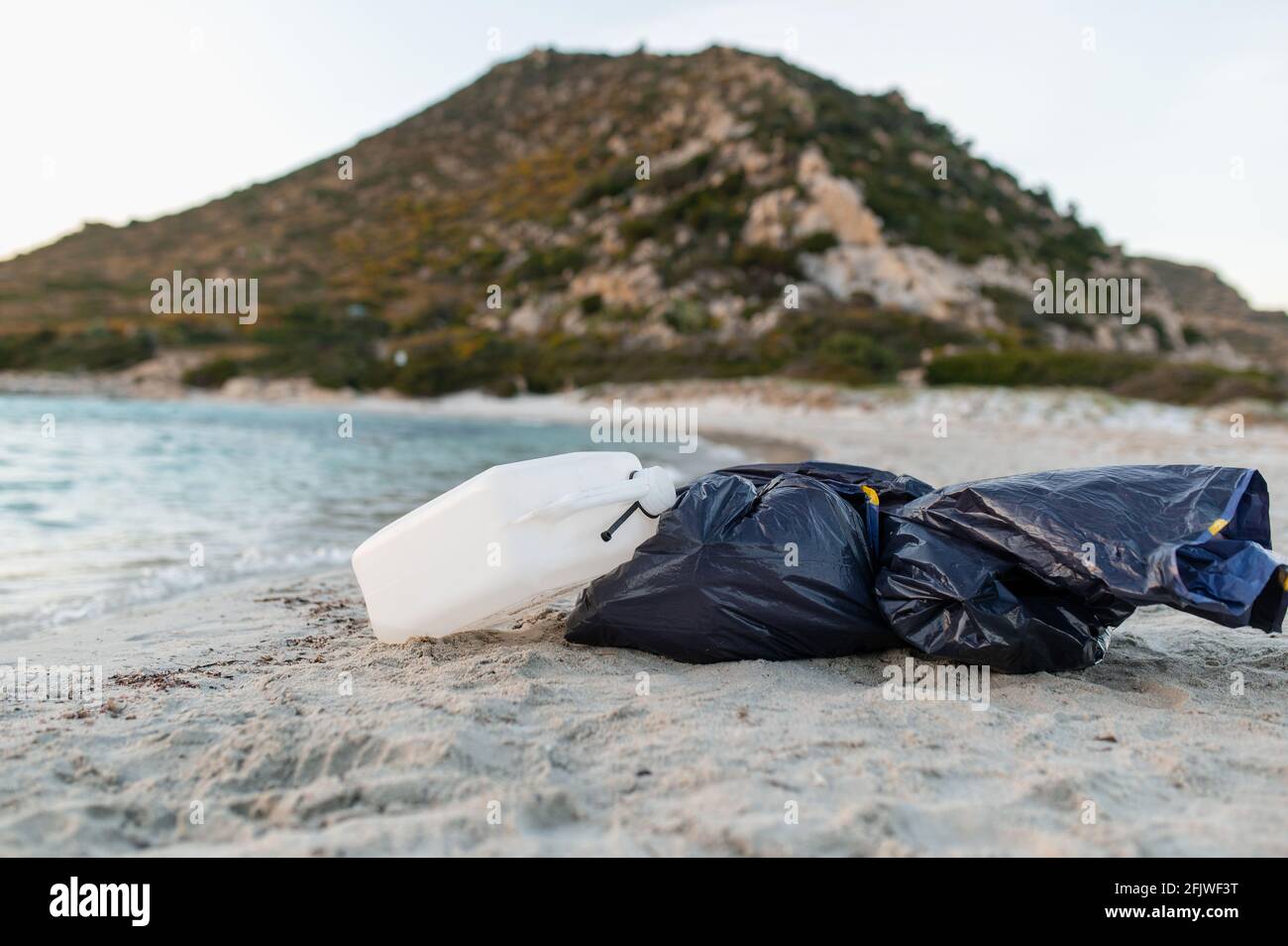 Nach dem Reinigen des Strandes liegen auf dem Sand Tüten voller Müll und Plastikbehälter. Ehrenamtliche Arbeit gegen Verschmutzung und Ozeankontamination Stockfoto