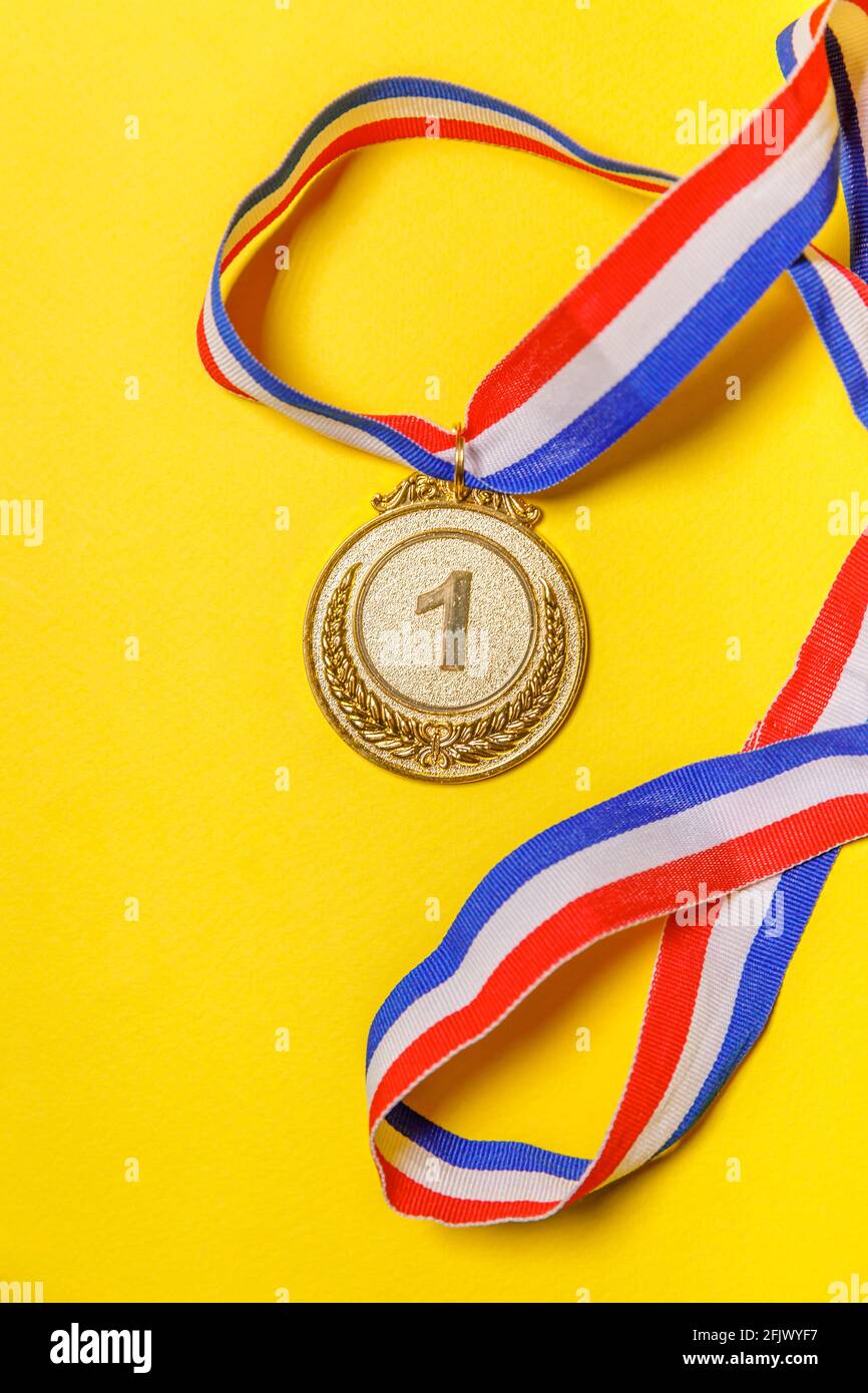 Einfach flach Lay Design Gewinner oder Champion Gold Trophäe Medaille isoliert auf gelb bunten Hintergrund. Sieg erster Platz des Wettbewerbs. Oder gewinnen Stockfoto