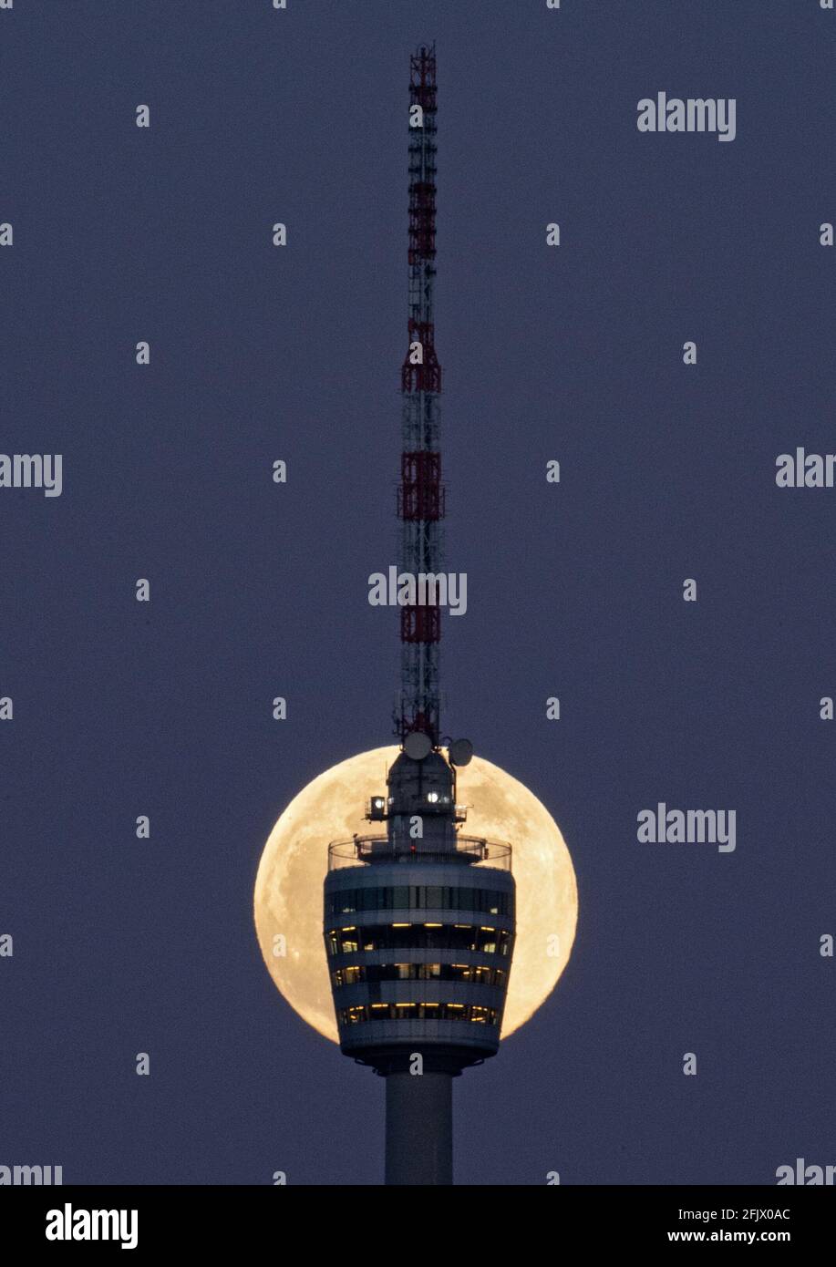 Stuttgart, Deutschland. April 2021. Der Vollmond steigt hinter dem Stuttgarter Fernsehturm auf. Am 27. April 2021 wird es einen sogenannten "Supermond" geben. Dann ist der Abstand zwischen Mond und Erde kleiner als üblich. Quelle: Marijan Murat/dpa/Alamy Live News Stockfoto