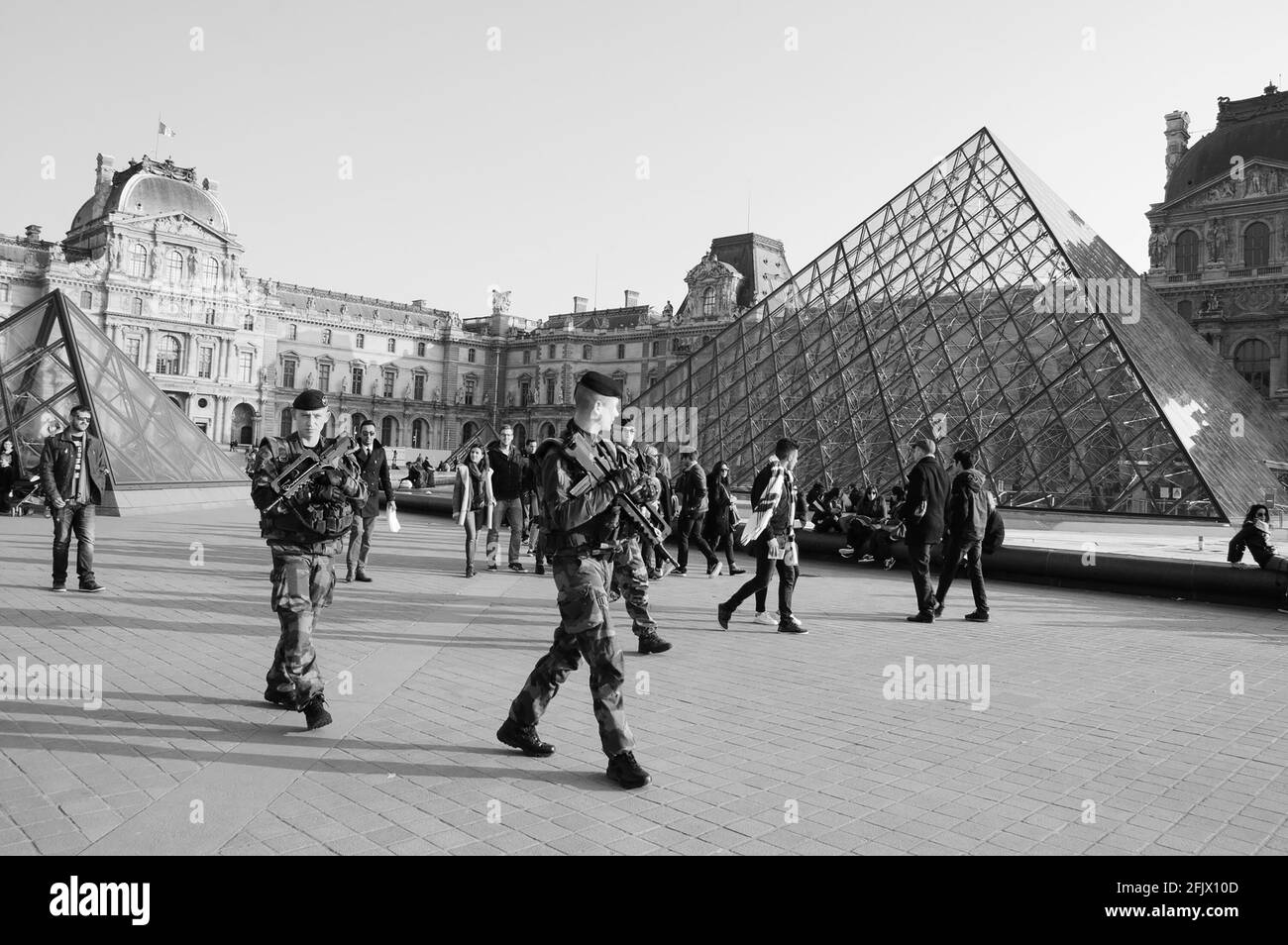 PARIS, FRANKREICH - 12. MÄRZ 2016: Soldaten patrouillieren in der Nähe des Louvre. Frankreich verstärkte die Maßnahmen zur Bekämpfung von Kriminalität und Terrorismus. Schwarz-weiß Stockfoto