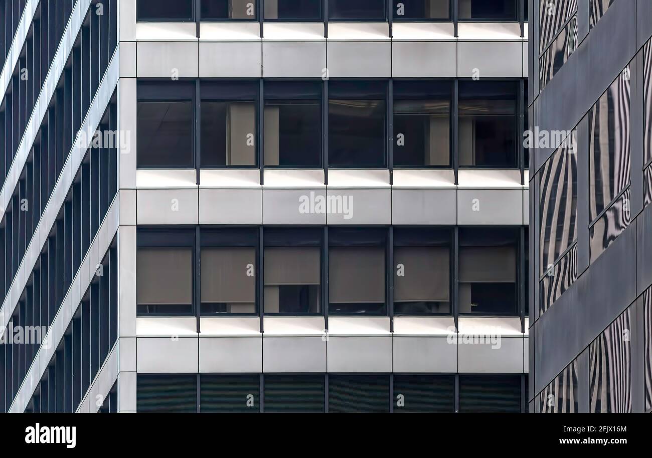 Glas- und Metallraster aus Flachfenstern in den Bürohochhäusern von Manhattan, 1180 und 1166 Avenue of the Americas. Stockfoto