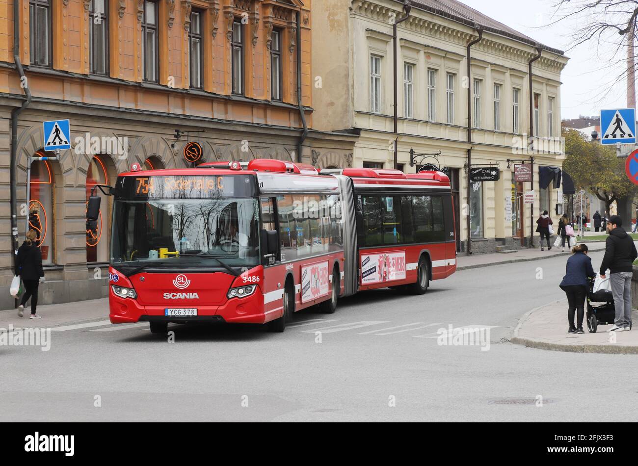 Sodertalje, Schweden - 24. April 2021: Ein drehend beweglicher Stadtbus von Scania auf der Storgatan-Straßenbetriebslinie 754. Stockfoto