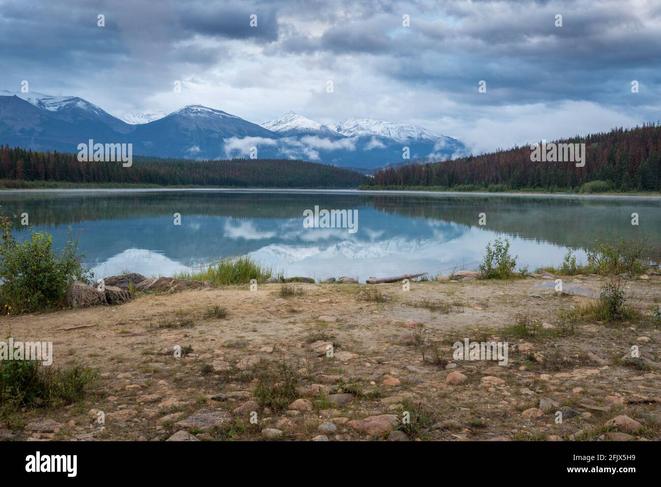 An einem kalten Sommerabend sammeln sich über dem Patricia Lake in den kanadischen Rockies Wolken. Abenddämmerung im Jasper National Park, Alberta, Kanada. Berge spiegeln sich in ca. Stockfoto