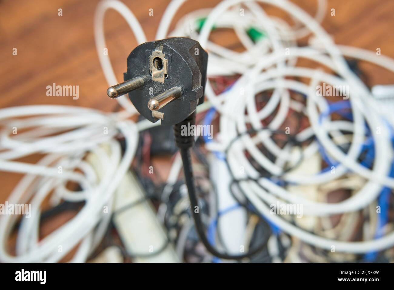 Auf dem Boden liegt ein verworrenes Gewirr unnötiger Drähte. Stockfoto