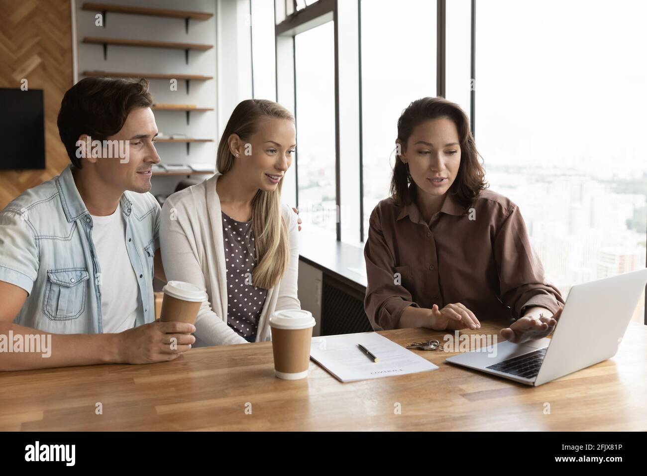 Weibliche Relator konsultieren aufgeregt paar Kunden im Büro Stockfoto