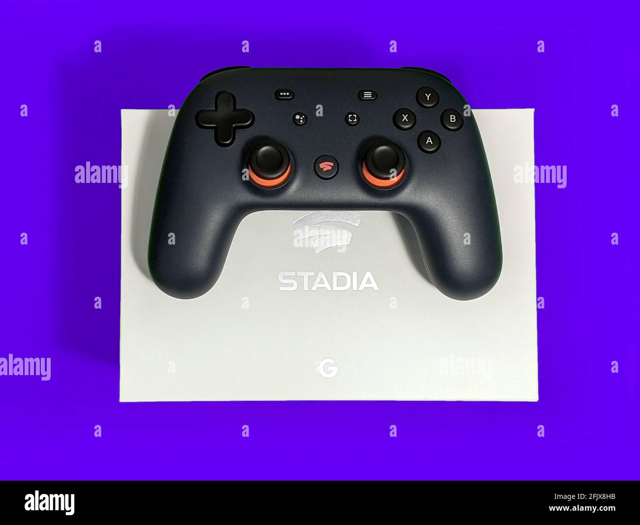 Seattle, WA / USA - ca. November 2019: Nahaufnahme eines Google Stadia Gaming Controllers, der auf einer weißen Box vor einem farbenfrohen Hintergrund ruht Stockfoto